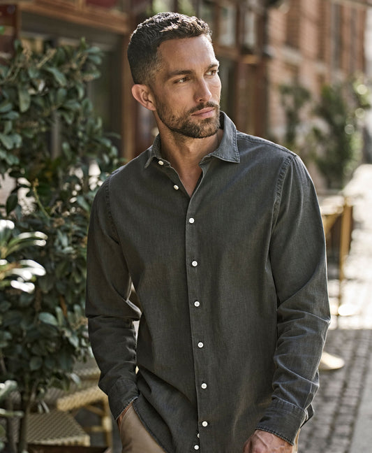 Man wearing the Tee Jays Men’s Denim Shirt in Black Denim, standing on a cobbled street