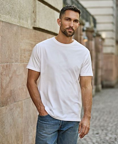 Man wearing the Tee Jays Men’s Sof-Tee T-Shirt, walking along a street