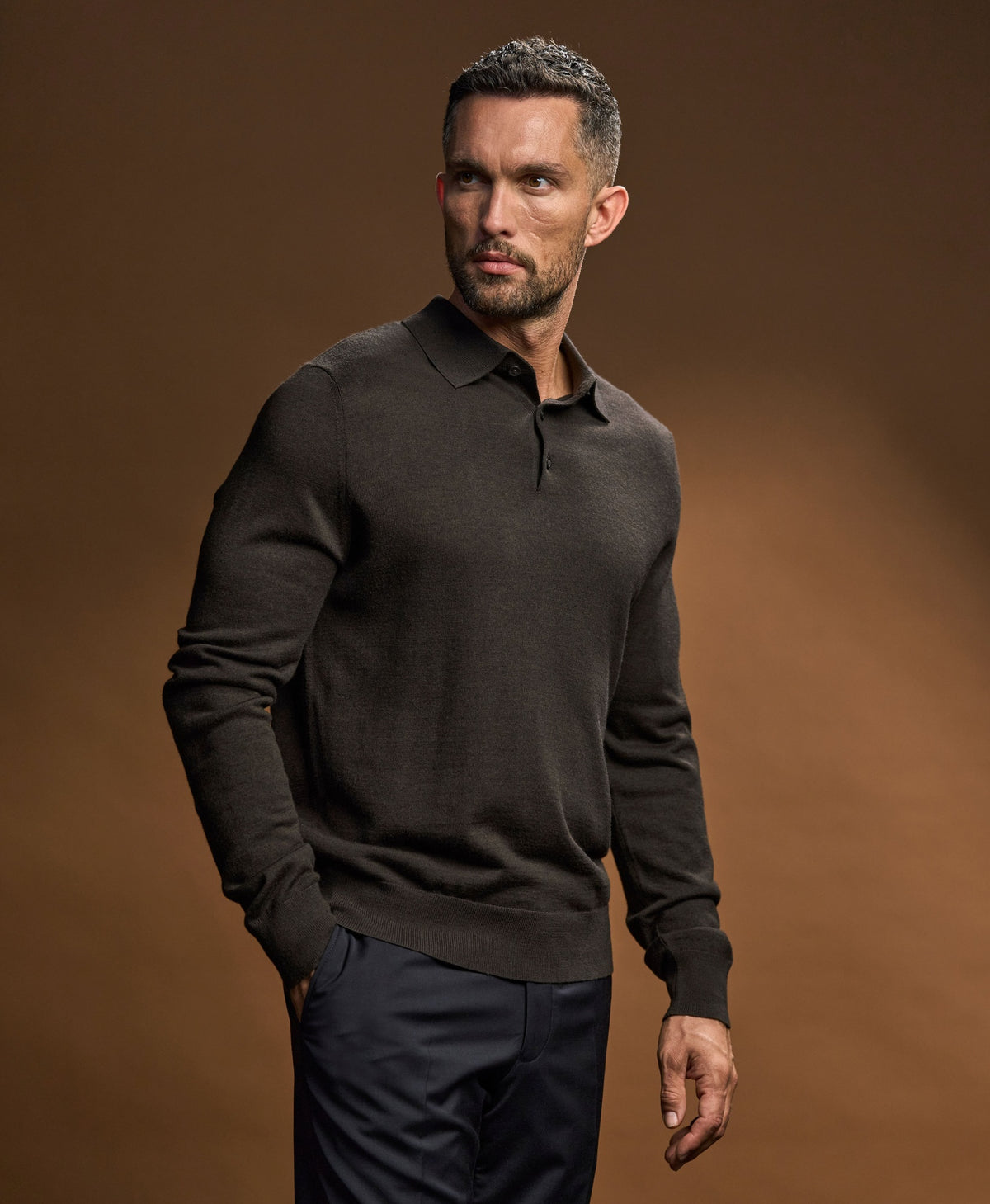 Model wearing the Tee Jays Men’s Knit Polo Shirt in Black, front view
