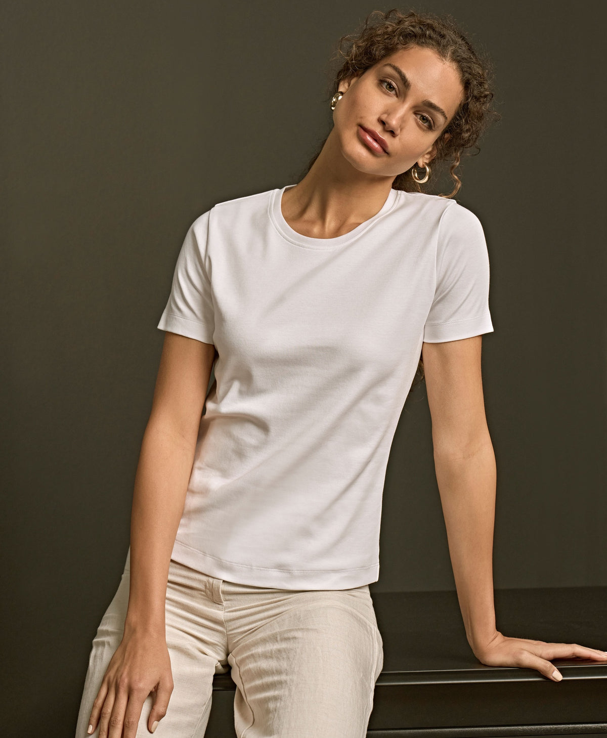Woman wearing the Tee Jays Ladies Interlock T-Shirt, leaning on a bench