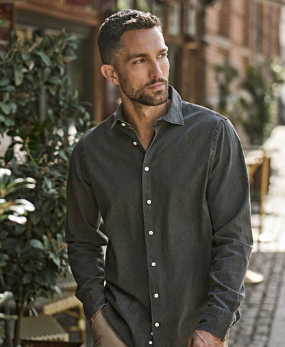 Man wearing the Tee Jays Men’s Denim Shirt in Black Denim, standing on a cobbled street