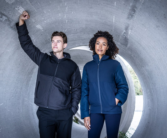 Man and woman wearing the Regatta Recycle.Me Thermal Jacket, standing in a concrete pipe