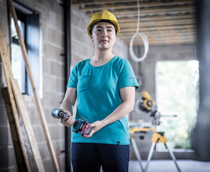 Woman in a hard hat wearing the Regatta Ada Ladies Cotton Stretch T-Shirt in Wilderness Green, holding a drill