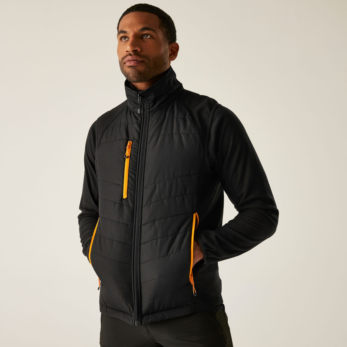 Model wearing the Regatta Pro Men’s Universal Bodywarmer in Black Orange Pop, front view