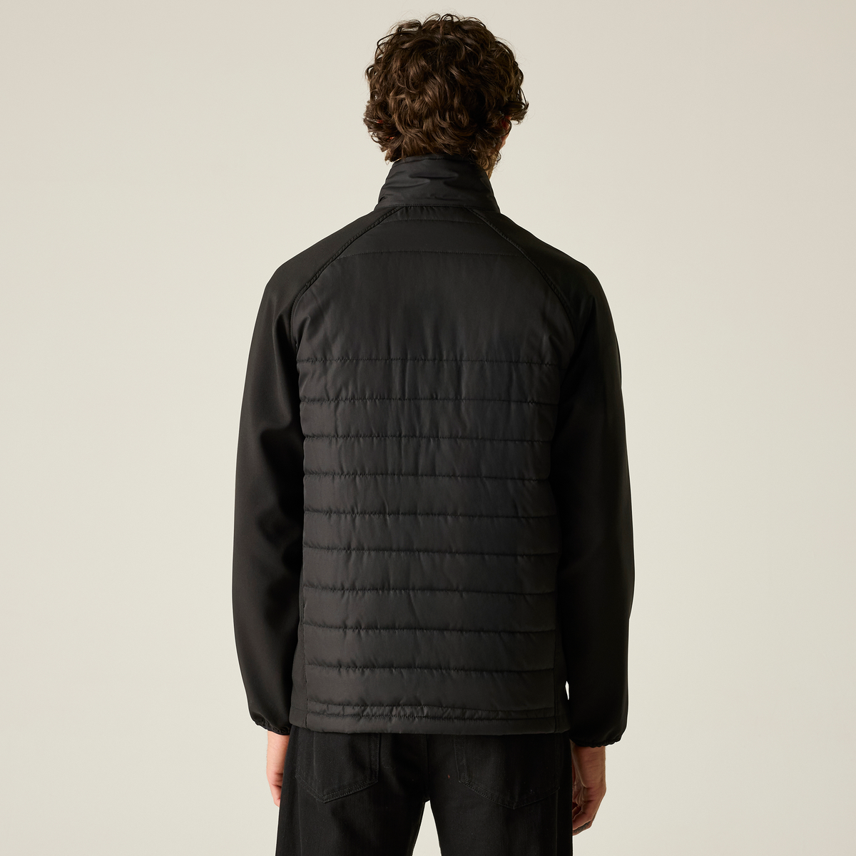 Model wearing the Regatta Pro Men’s Universal Jacket in Black Orange Pop, back view