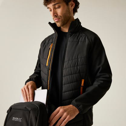 Model wearing the Regatta Pro Men’s Universal Jacket in Black Orange Pop, unzipped, reaching into a bag