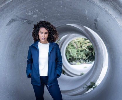 Woman wearing the Regatta Recycle.Me Thermal Jacket in Navy, standing in a concrete pipe