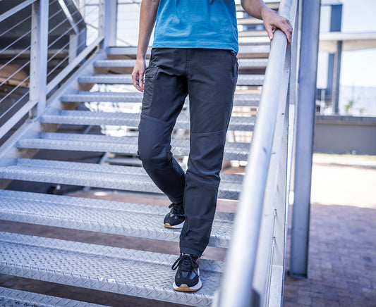Woman wearing the Regatta Prolite Ladies Stretch Trousers in Navy, walking down metal steps