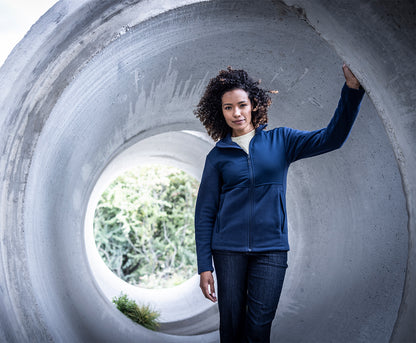 Woman wearing the Regatta Recycle.Me Unisex Fleece Jacket in Navy, leaning in a concrete pipe