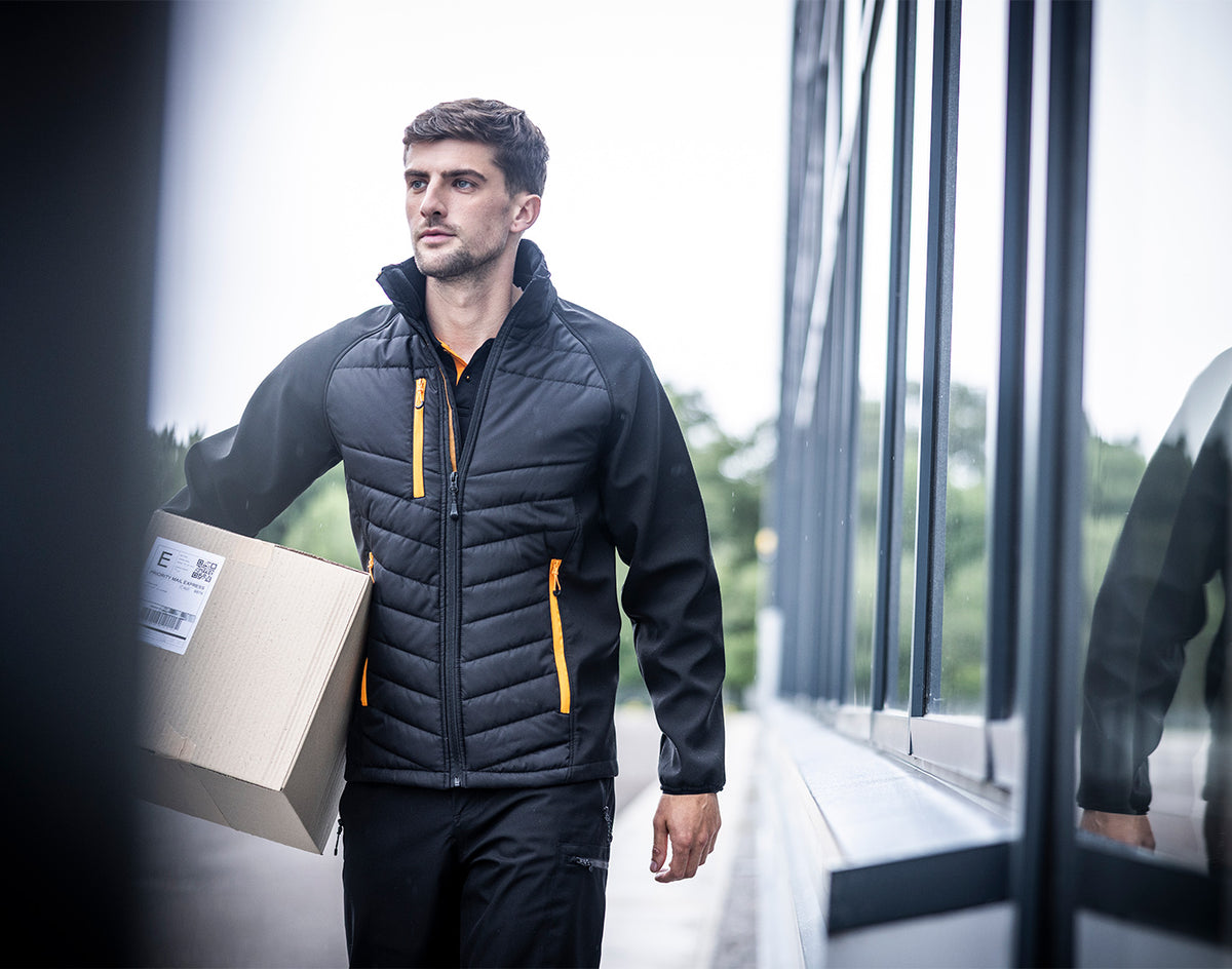 Man wearing the Regatta Pro Men’s Universal Jacket, carrying a box out of an office building