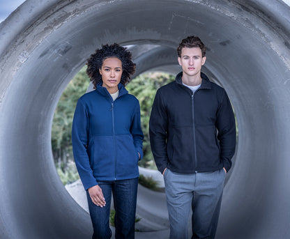 Woman and man wearing the Regatta Recycle.Me Unisex Fleece Jacket, standing in a concrete pipe