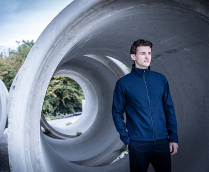 Man wearing the Regatta Recycle.Me Unisex Softshell Jacket in Navy, standing in a concrete pipe
