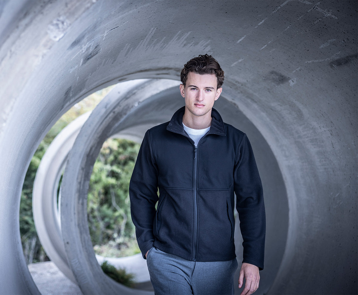 Man wearing the Regatta Recycle.Me Unisex Fleece Jacket in Navy, standing in a concrete pipe