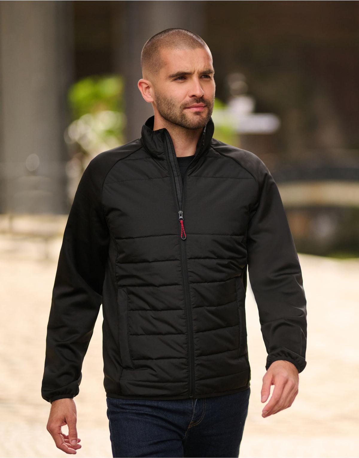 Man wearing the Regatta Essential Men's Hybrid Jacket in Black, walking outdoors