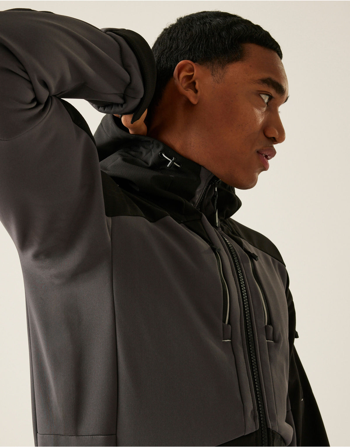 Model wearing the Regatta 4TEX Men's Stretch 3-Layer Softshell Jacket in Slate Grey and Black, side view, hood down