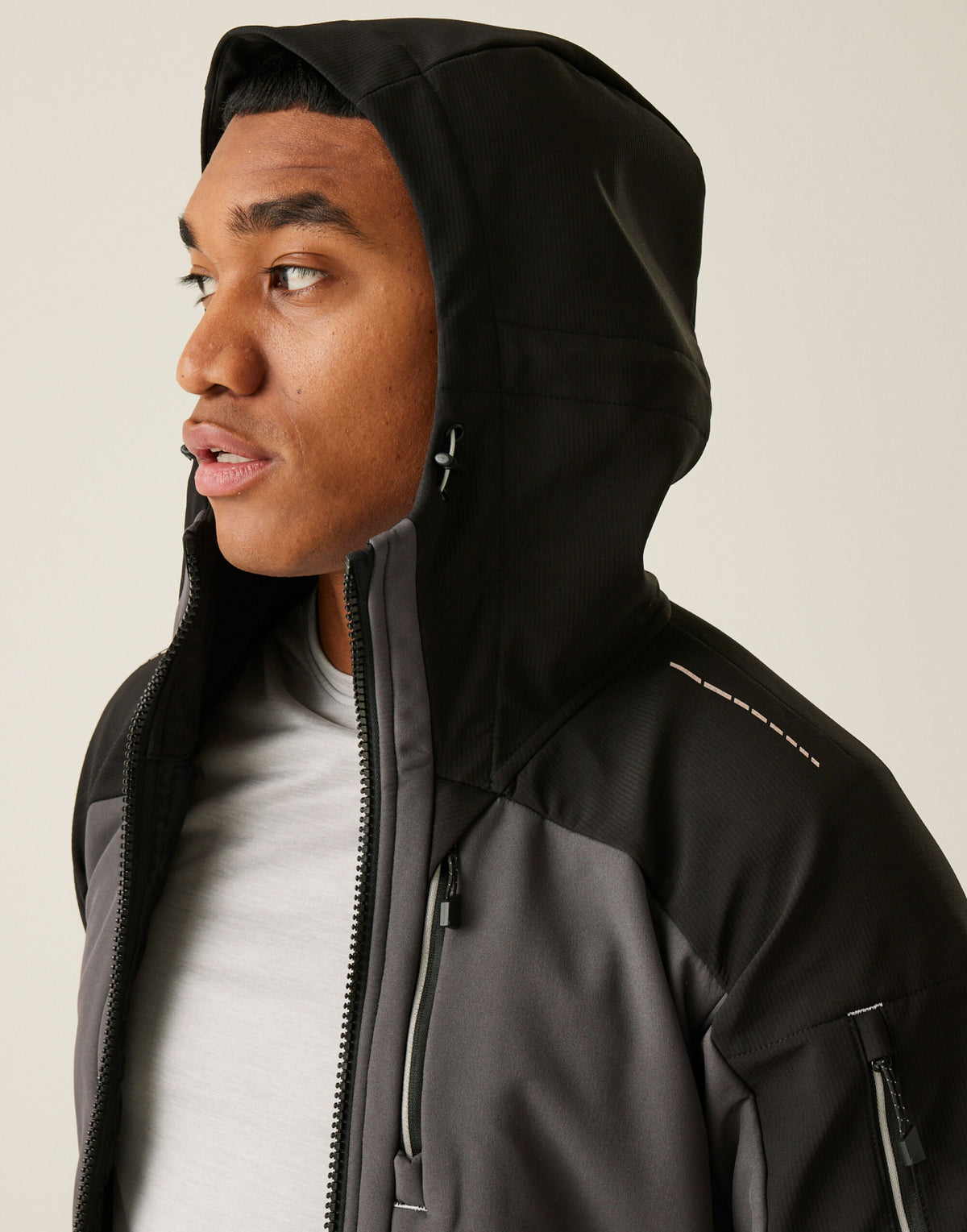 Model wearing the Regatta 4TEX Men's Stretch 3-Layer Softshell Jacket in Slate Grey and Black, side view, hood up