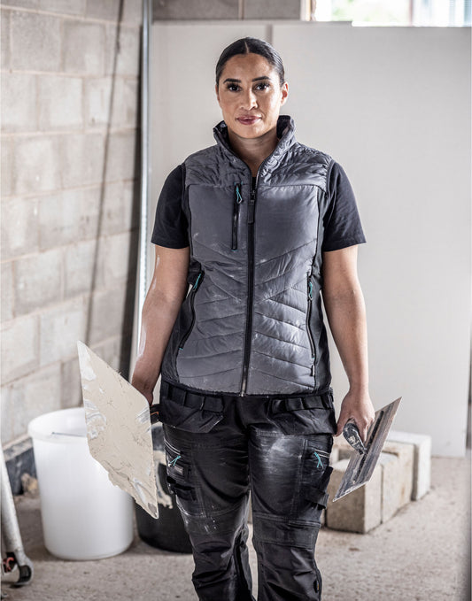 Woman wearing the Regatta Ada Ladies Hybrid Bodywarmer, carrying tiles on a building site