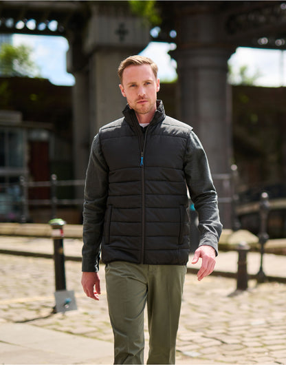 Man wearing the Regatta Essential Men's Thermal Bodywarmer in Black, walking along a cobbled street