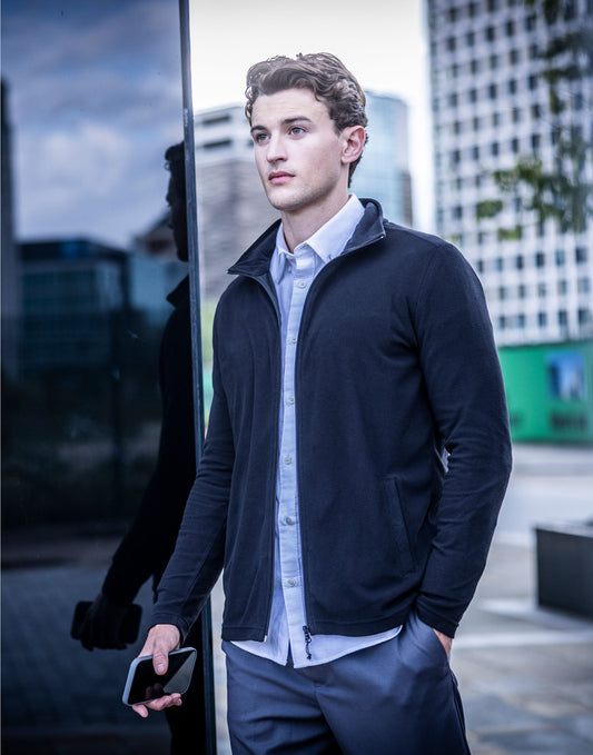 Man wearing the Regatta Pro Men’s Ultra Light Fleece Jacket in Navy, holding a phone in the city