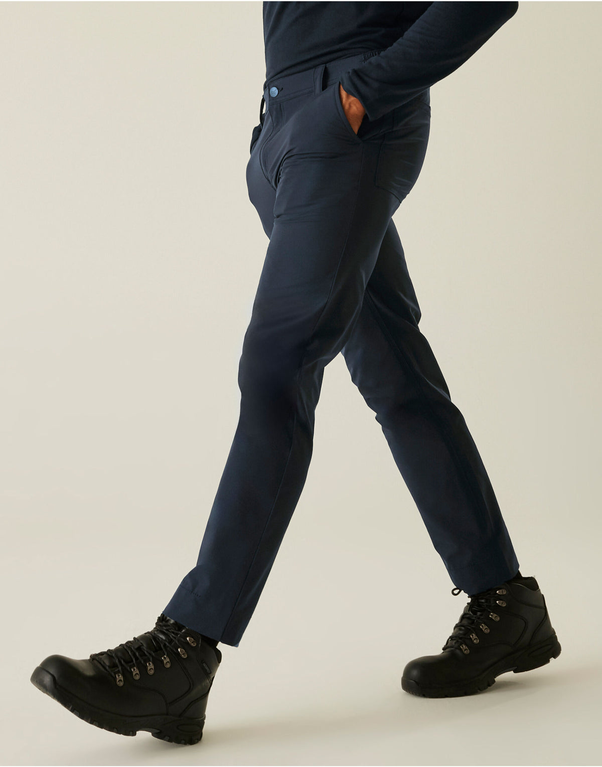 Model wearing the Regatta Pro Men’s Action Stretch Trousers Shorter Fit in Navy, side view, walking