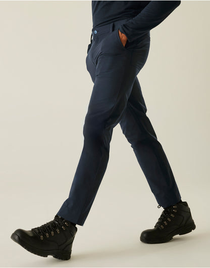 Model wearing the Regatta Pro Men’s Action Stretch Trousers Shorter Fit in Navy, side view, walking