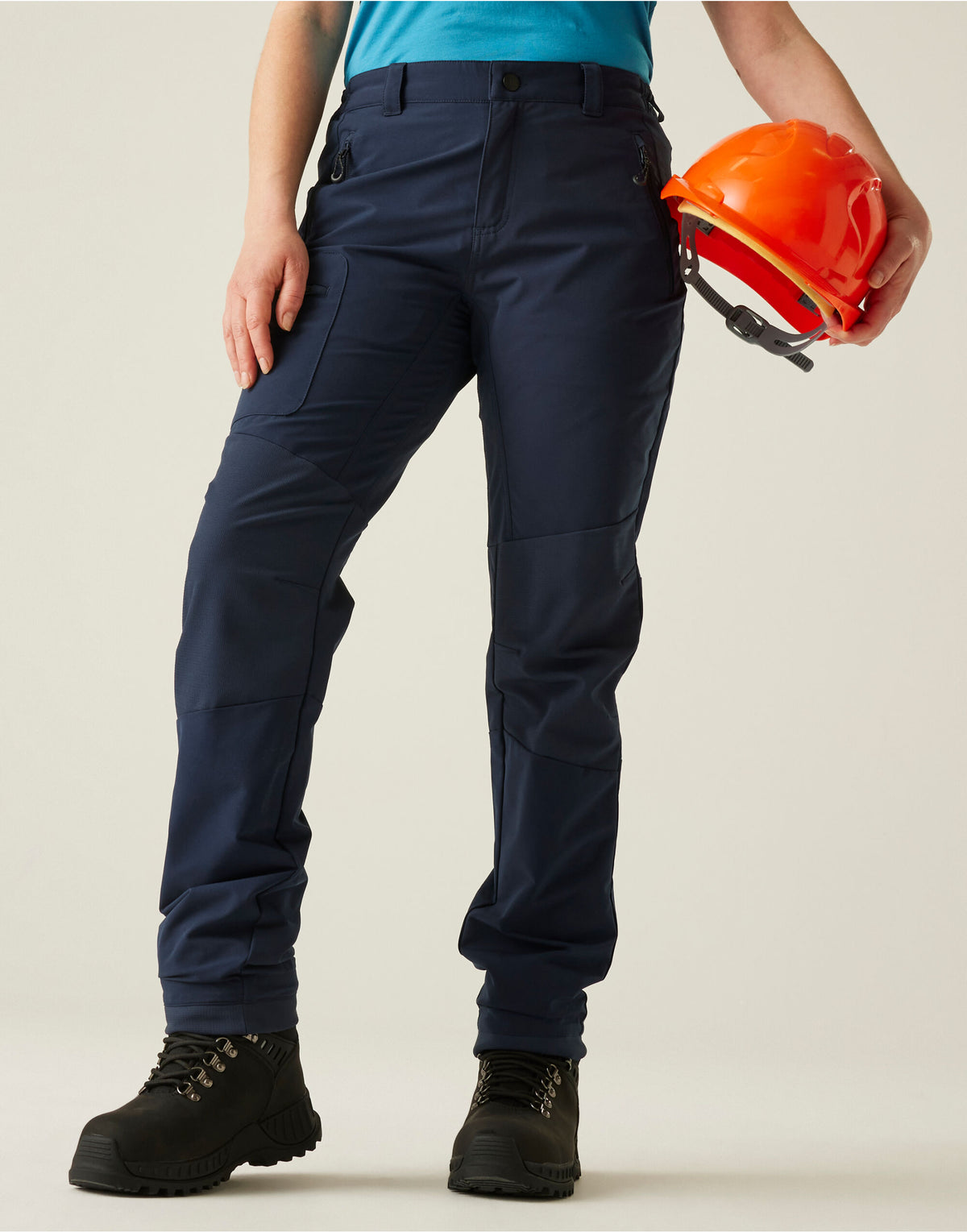 Model wearing the Regatta Prolite Ladies Stretch Trousers Shorter Fit in Navy, front view, holding a hard hat