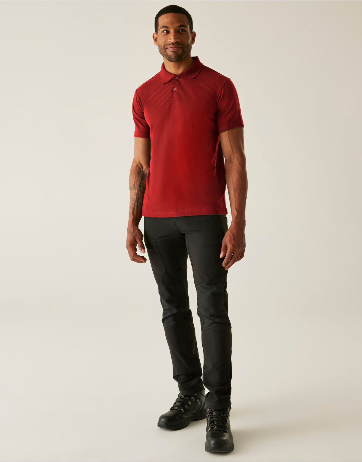 Model wearing the Regatta Pro Men’s 50/50 Pique Polo Shirt in Red, front view, full length