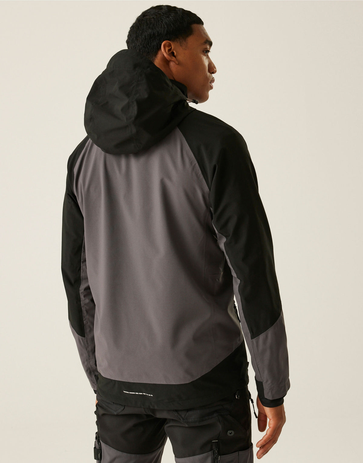 Model wearing the Regatta 4TEX Men's Stretch Waterproof Shell Jacket in Slate Grey and Black, back view, hood up