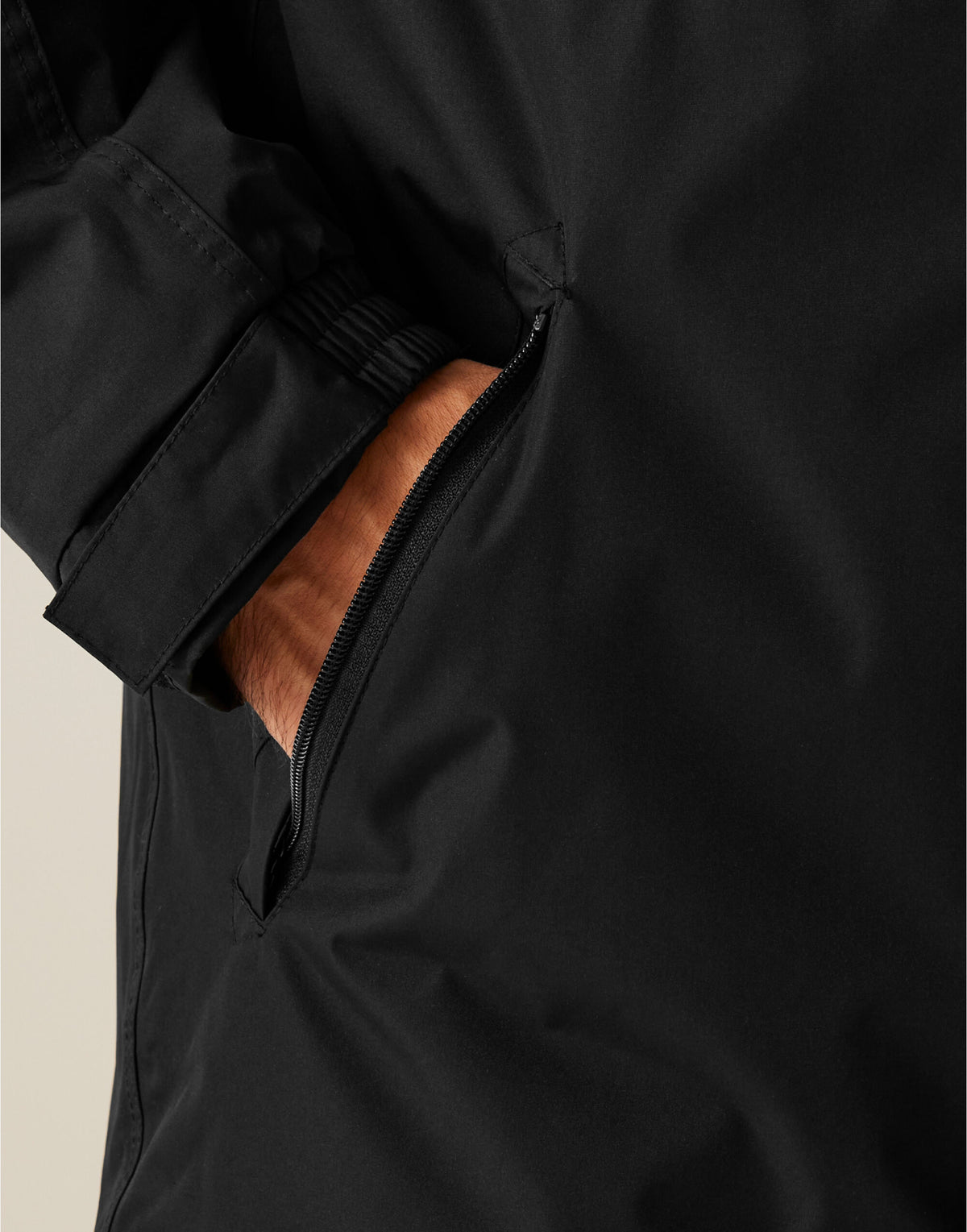 Close-up of a hand in the zipped pocket of the Regatta Dover Men's Parka in Black